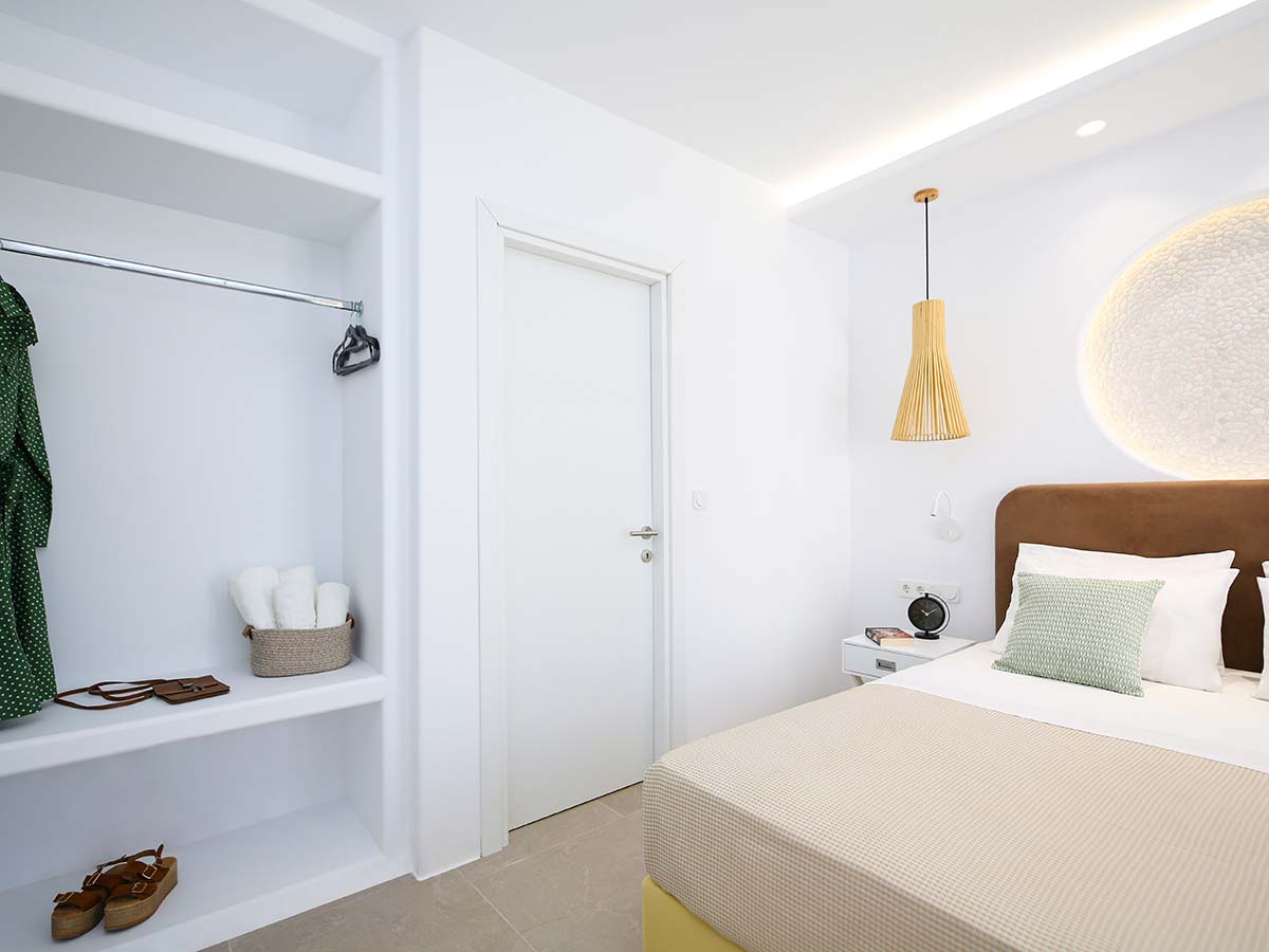 Φωτεινό υπνοδωμάτιο της One-Bedroom Villa στη Νάξο με διπλό κρεβάτι και ανοιχτή ντουλάπα