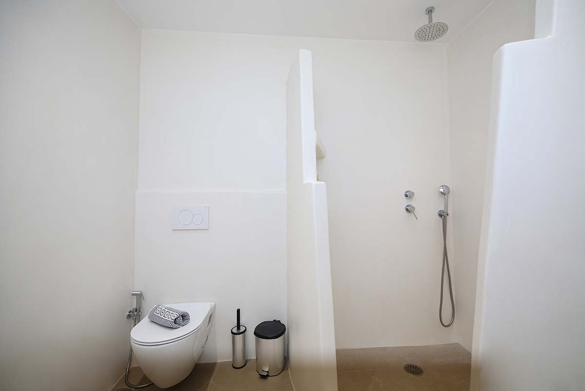 Μπάνιο της Six-person villa με χτιστό ντους και minimal σχεδιασμό